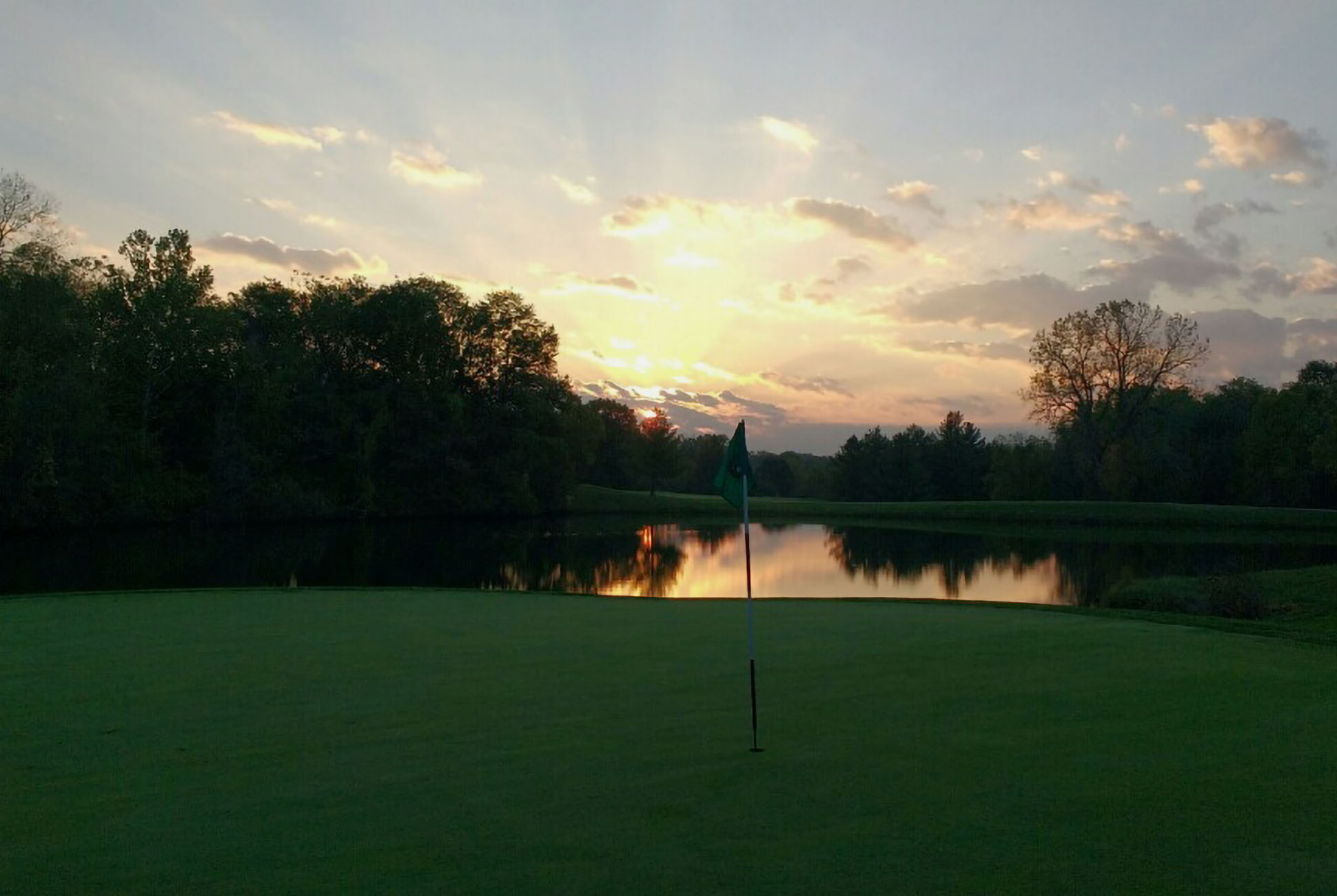 green with creek in the background against the sunset